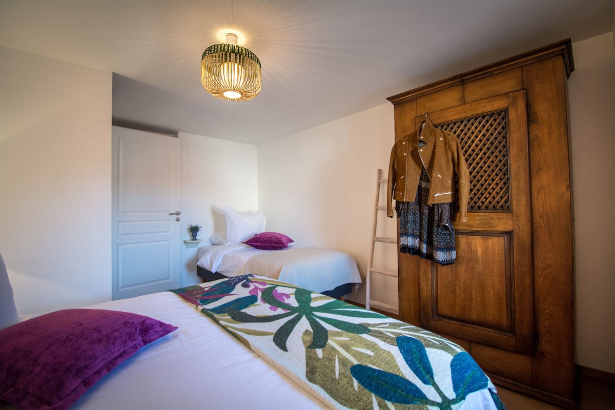 Een slaapkamer met een bed, een kledingkast, een kapstok en een plafondlamp.