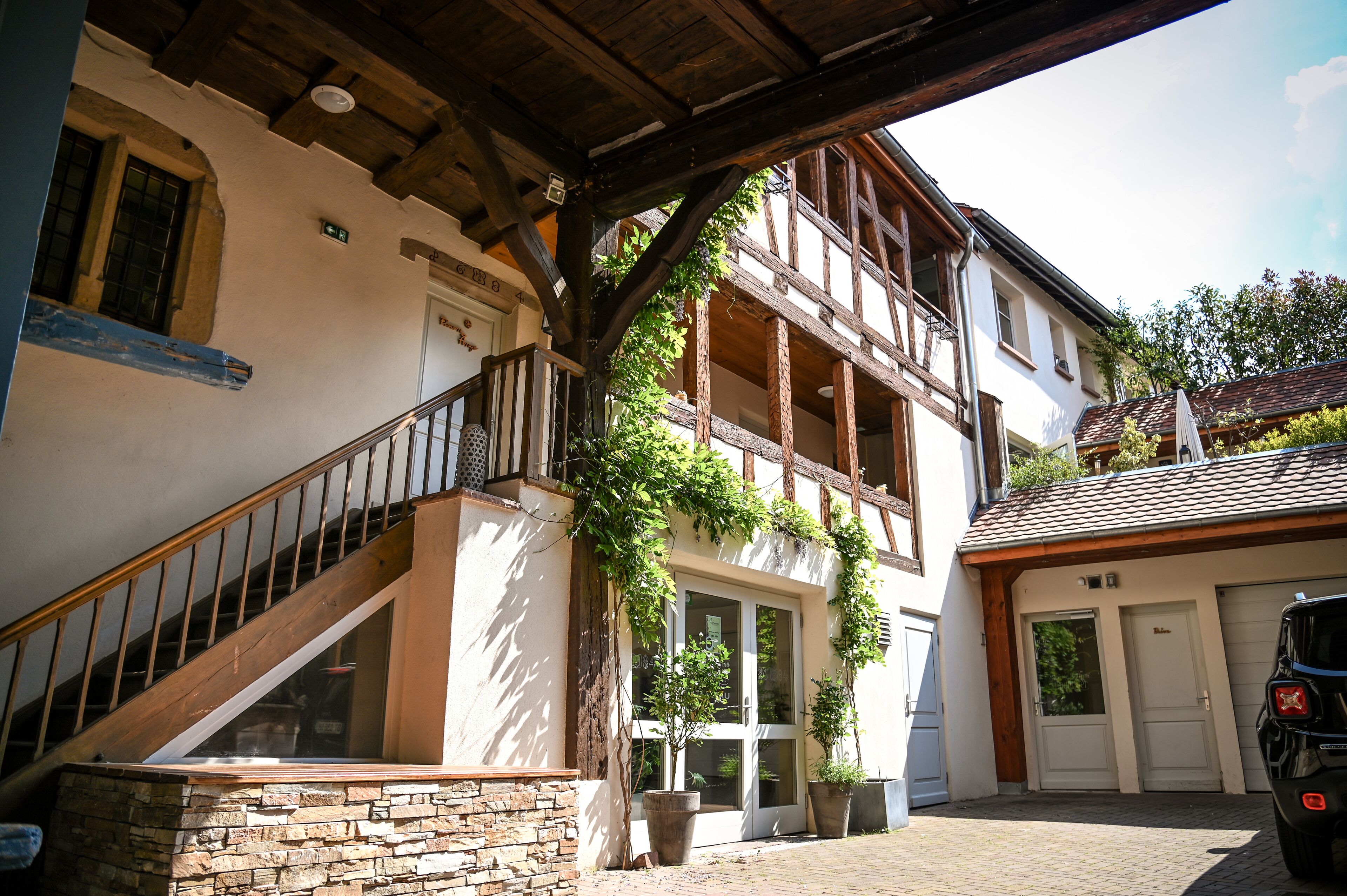 A traditional building with a stone staircase, wooden beams, and a garage.