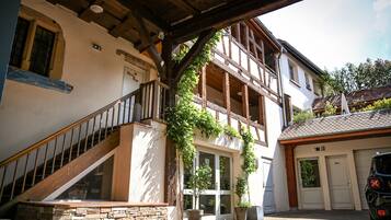 A traditional building with a stone staircase, wooden beams, and a garage.