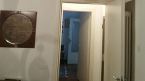 A narrow hallway with a wooden ceiling and a door leading to another room. - B&B All'Aeroporto (Curtatone)