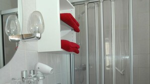 A modern bathroom with a white sink, a glass shower enclosure, and a red towel rack. - Hotel Scheffelhof (Waldkirch)