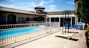 Una piscina al aire libre de temporada, sillones reclinables de piscina