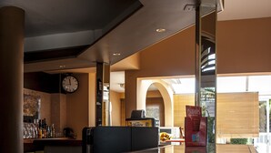 A spacious lobby with a reception desk, a clock, and a glass partition. - Hôtel Leukos (Leucate)