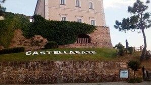Un edificio histórico con fachada de piedra y un cartel que dice 'CASTELLABATE'.