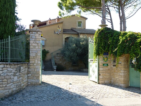 Un edificio de piedra con una reja, una escalera y un cartel que indica que es una casa rural.