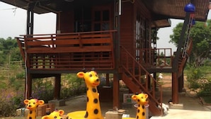 A wooden house with a balcony and a staircase. - Romsiri Resort (Sung Noen)
