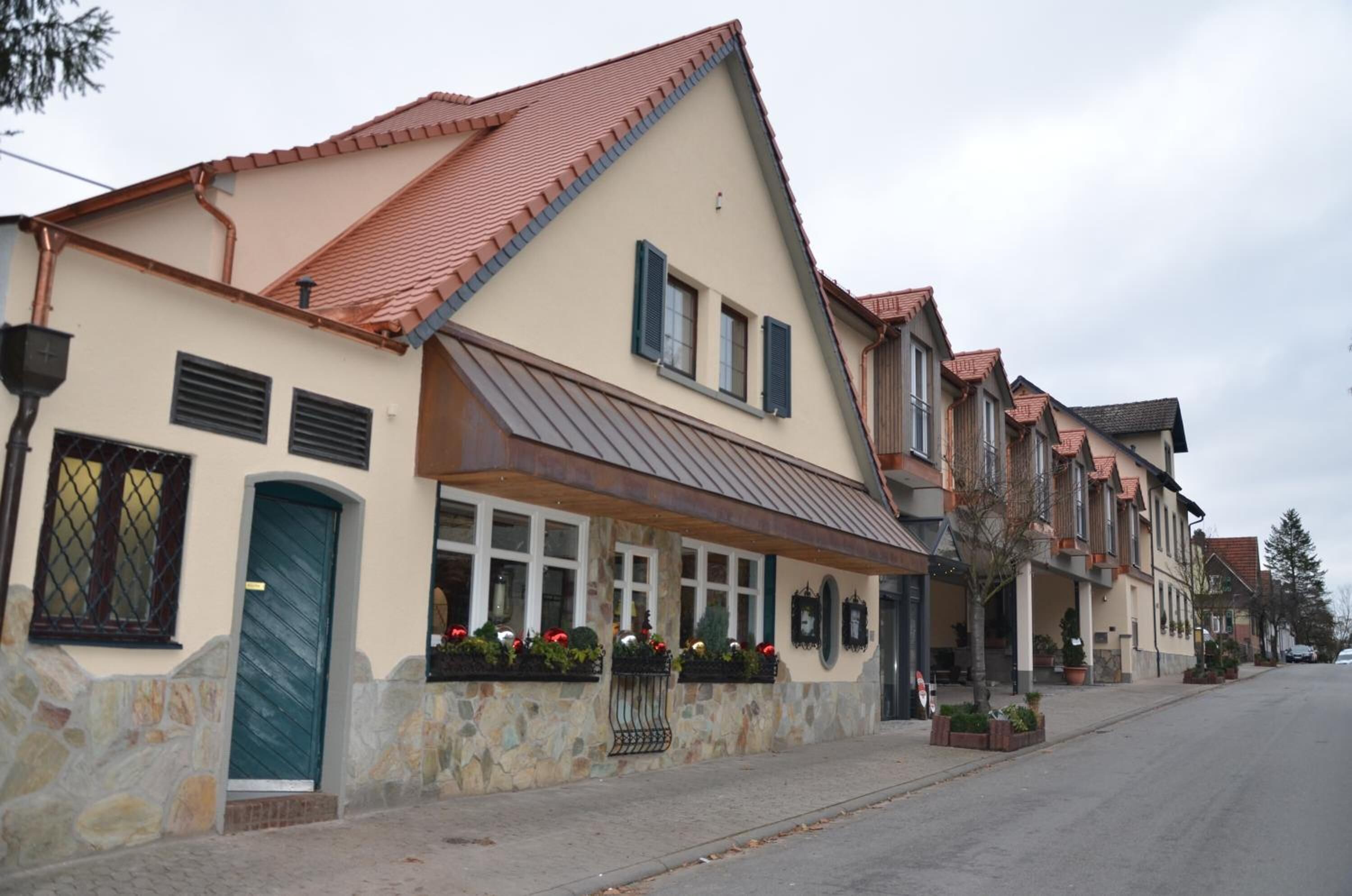 A row of traditional European-style buildings with stone facades, red-tiled roofs, and multiple windows.