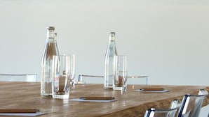 A table set with bottles and glasses, overlooking a scenic landscape. - Le Panoramic Hôtel (Sancerre)