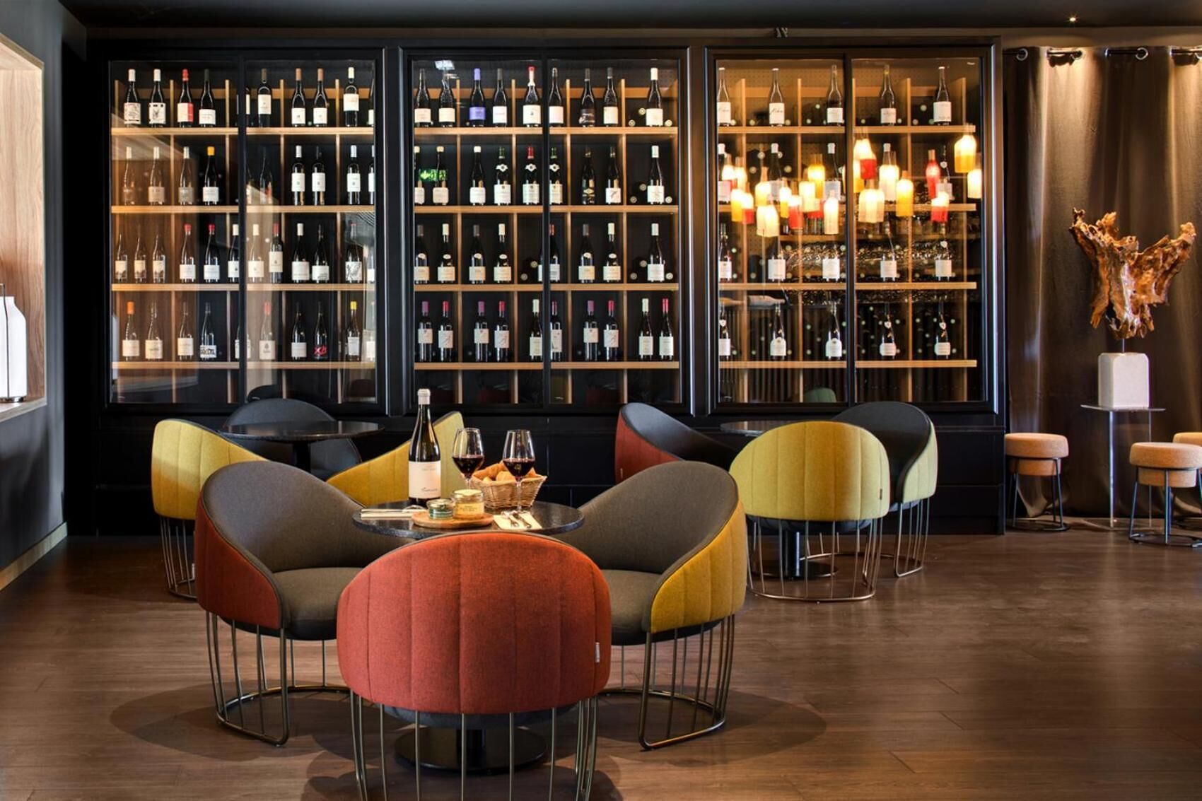A bar area with multiple seating options and a wine display.