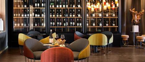 A bar area with multiple seating options and a wine display.