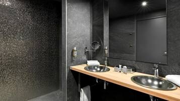 Un bagno moderno con due lavabi, uno specchio grande e una parete doccia con texture.
