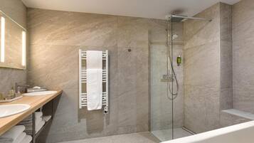 Une salle de bain moderne avec une douche à parois de verre, une baignoire blanche et un meuble-lavabo doté de deux vasques.