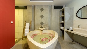 A bathroom with a freestanding bathtub filled with water and rose petals, a wooden ladder, a towel rack, and a large mirror. - Charming Angkor Resort & Spa (Siem Reap)