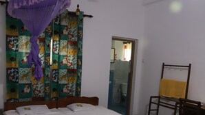 A room with a bed, a ceiling fan, a shower area, and a chair. - prasad suomi villa (Matara)