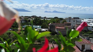A coastal town with buildings, a clear sky, and a view of the sea. - The Last Floor (Torre del Greco)