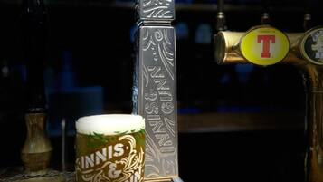 A glass of beer with "Innis & Gunn" on the label, a tap labeled "Innis & Gunn Session IPA," and a coaster with "Innis & Gunn" and "Scotland" on it.