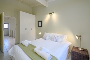 Cozy retreat with a neatly made bed, bedside table, and wardrobe.
