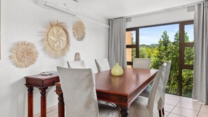 Un comedor con mesa de madera, seis sillas y decoración mural.