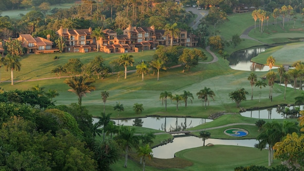 Un campo de golf con un club de campo y varios edificios.