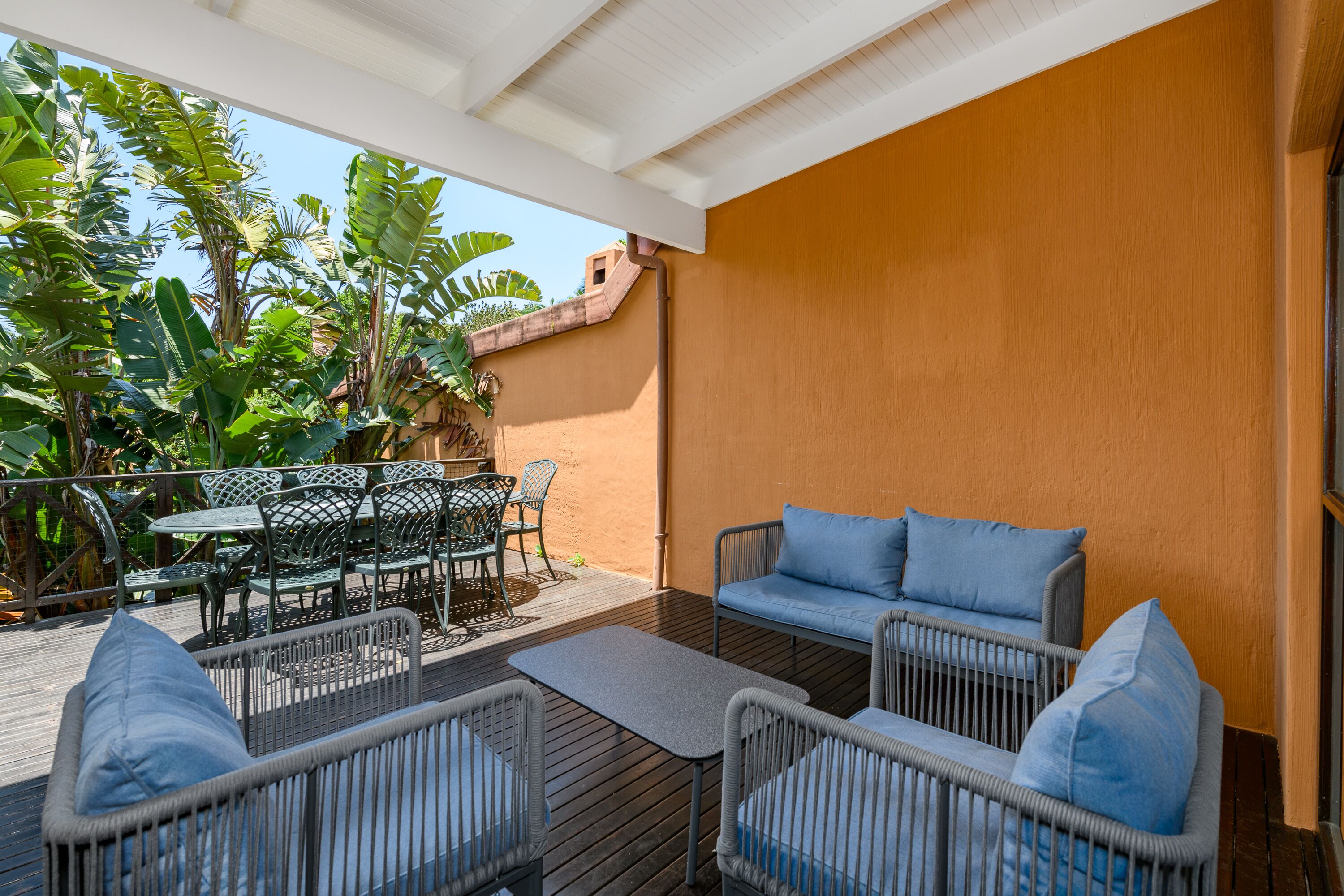 An outdoor patio with wicker furniture, a table, and a sofa.