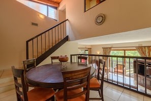 Enjoy meals in this dining area with a round table and six chairs, surrounded by a high ceiling and large window.
