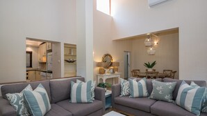 A living room with two sofas, a coffee table, and a dining area with a table and chairs. - San Lameer Villa Rentals 3404 (Southbroom)