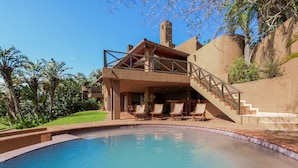 A poolside area with a clear view of a pool, lounge chairs, and a staircase leading to a covered deck. - San Lameer Villa Rentals 13937 (Southbroom)