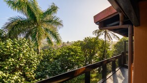 A wooden deck with a metal railing overlooking a lush garden with various trees and shrubs. - San Lameer Villa Rentals 3005 (Southbroom)