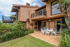 A two-story building with a balcony, outdoor seating, and a garden area. - San Lameer Villa Rentals 2529 (Southbroom)