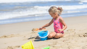 A child playing with sand on a beach.