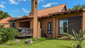 A modern house with a tiled roof, a chimney, and a covered porch. - San Lameer Villa Rentals 2702 (Southbroom)