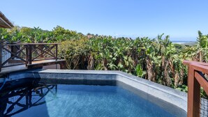 A swimming pool with a view of lush vegetation and distant buildings. - San Lameer Villa Rentals 14205 (Southbroom)
