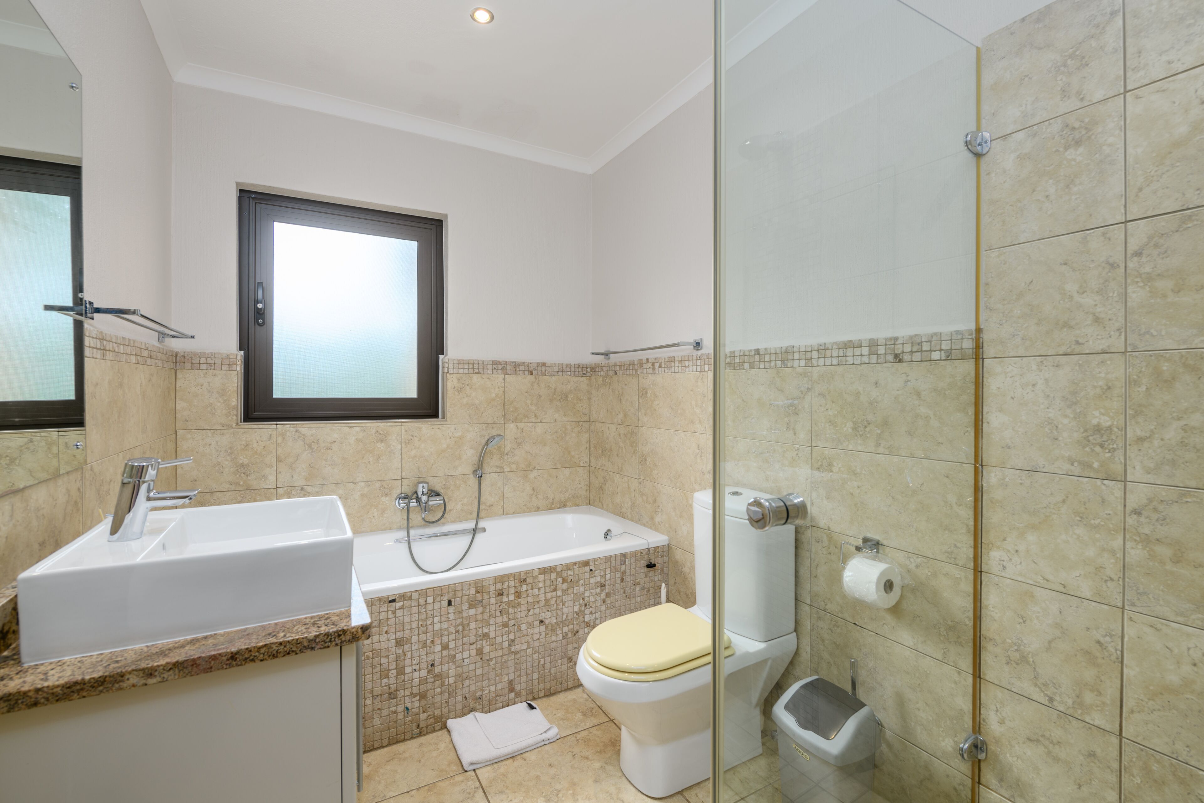 A bathroom with a sink, bathtub, toilet, and shower.