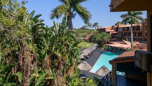 Un resort con piscina, palmeras y vistas de los edificios del hotel.