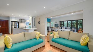 A modern living room with two sofas, a kitchen area, and a view of the outdoors. - San Lameer Villa Rentals 14105 (Southbroom)