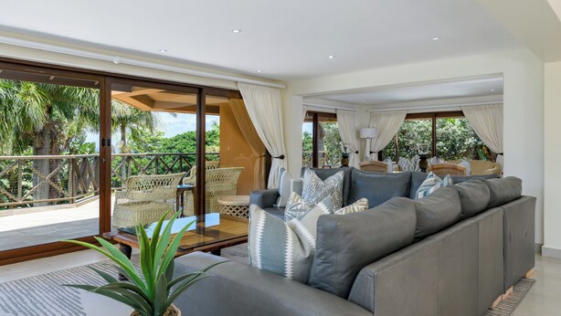 A modern living room with a grey sofa, a coffee table, and a potted plant. - San Lameer Villa Rentals 14014 (Southbroom)