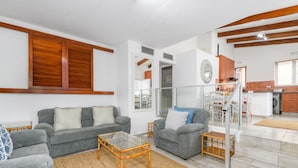 A modern living room with two grey sofas, a glass coffee table, and a wooden floor. - San Lameer Villa Rentals 1914 (Southbroom)