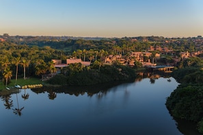 A riverside view of a residential area with houses, palm trees, and a calm river. - San Lameer Villa Rentals 1929 (Southbroom)