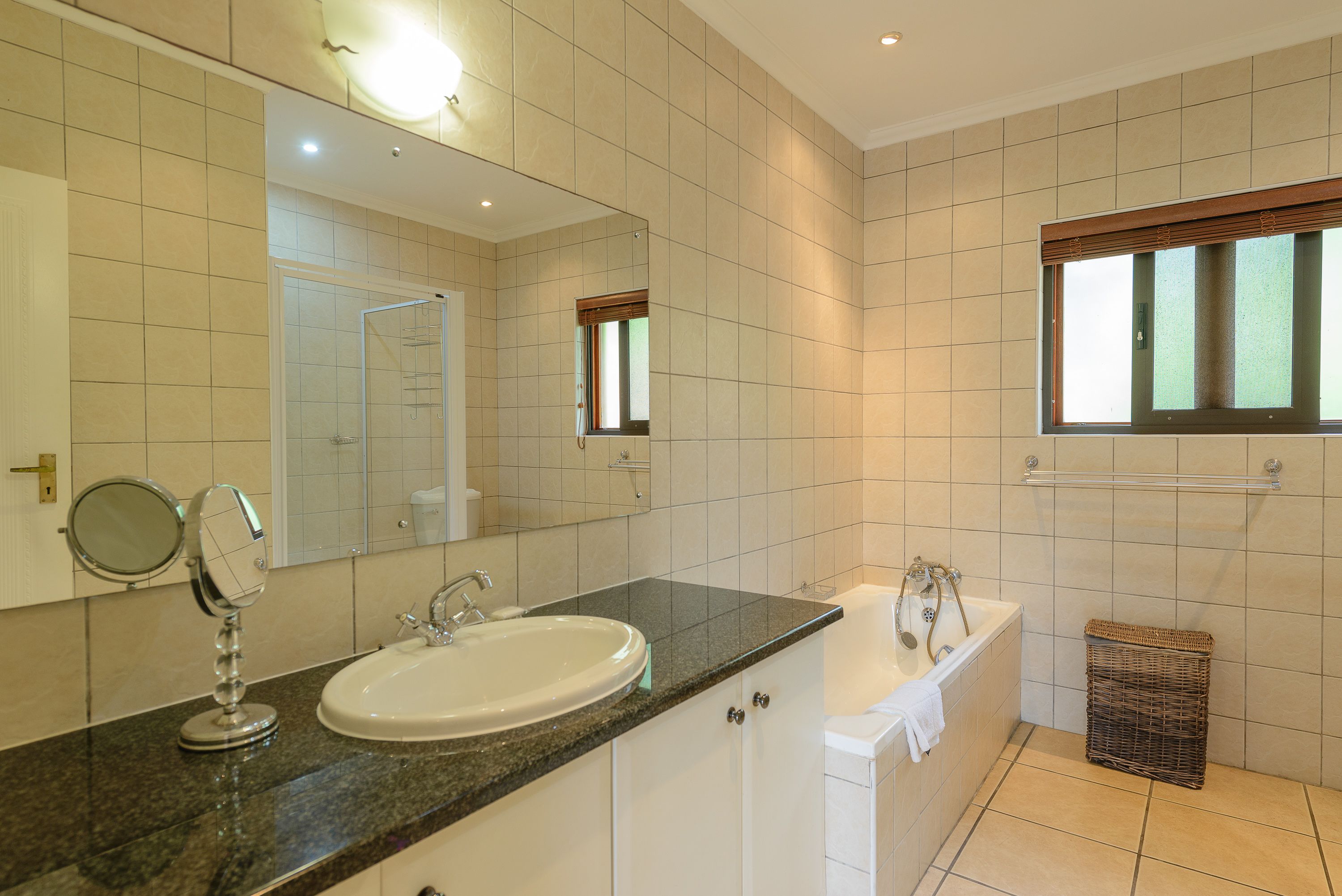 Un baño con lavamanos, espejo y bañera.