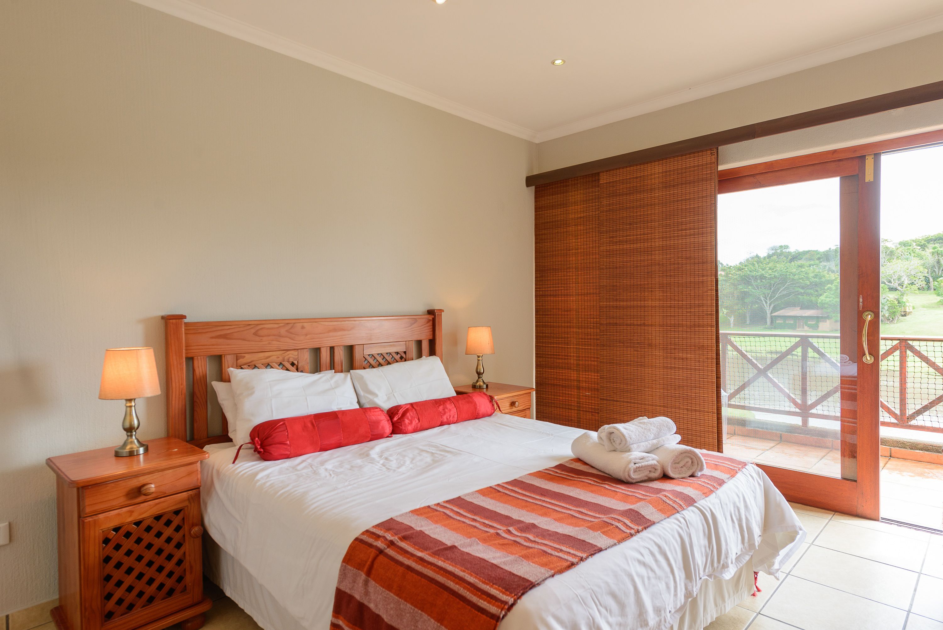 Una habitación de hotel con cama, mesitas de noche y vistas al exterior.