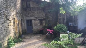 A stone building with a gravel path leading to a door. - Le Moulin à Huile (Vailhourles)