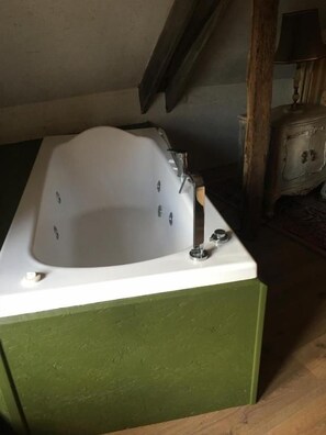 Un baño con una bañera, un grifo y un armario de madera.