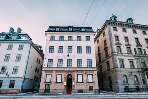 Three historic buildings with classic architecture, featuring multiple windows and a central entrance.