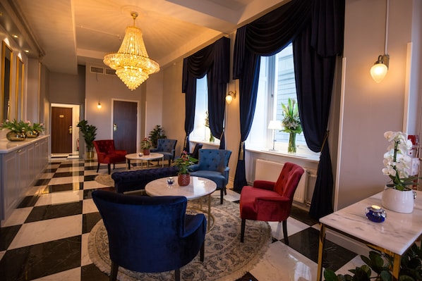 A hotel lobby with a checkered floor, a chandelier, and a mix of red and blue armchairs. - Hotel Gamla Stan, BW Signature Collection (Stockholm)