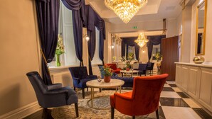 A hotel lobby with a checkered floor, a chandelier, and blue and red chairs. - Hotel Gamla Stan, BW Signature Collection (Stockholm)
