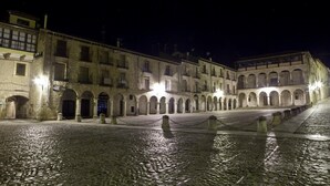 A historic building with multiple arches and a cobblestone courtyard at night. - Hospedería Porta Coeli (Siguenza)
