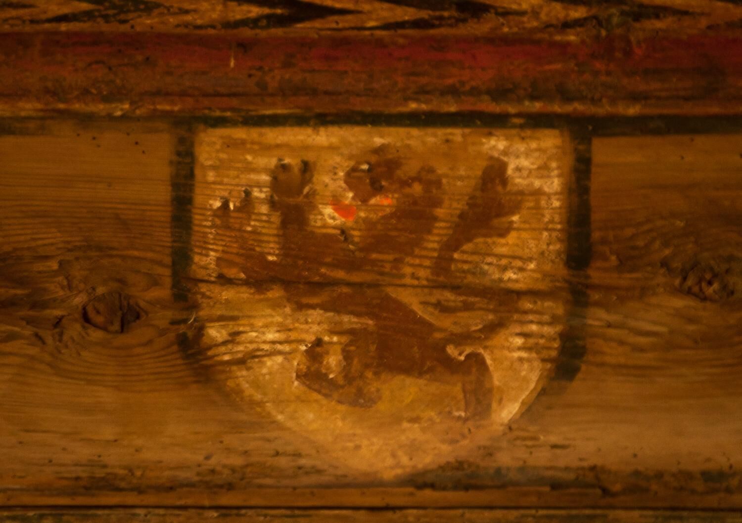 Et nærbillede af en træoverflade med et udskåret emblem.
