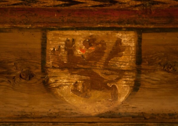 Primer plano de una superficie de madera con un emblema grabado.