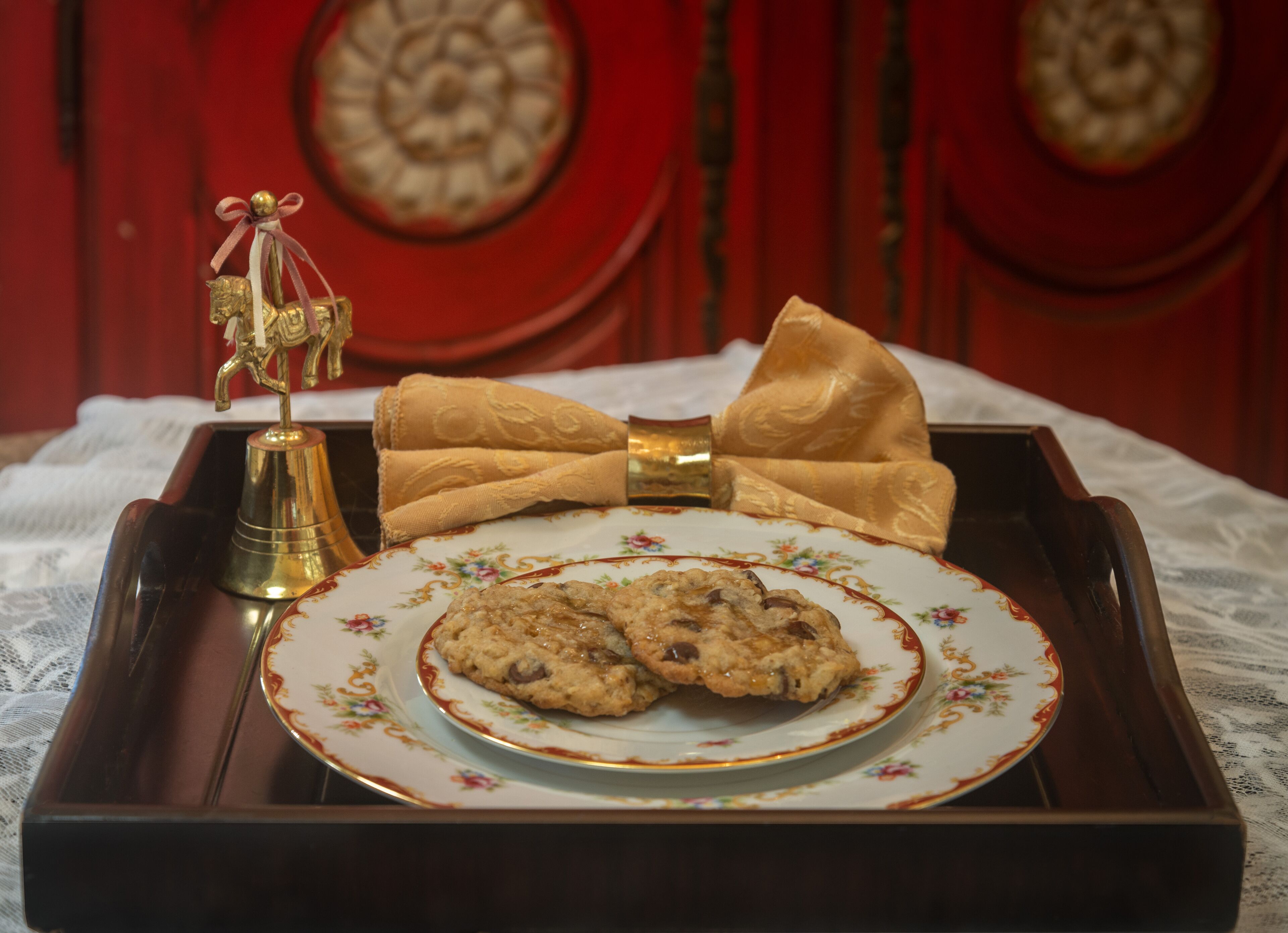 A tray with a plate of cookies and a decorative bow.