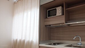 A modern kitchen with a microwave, sink, and wooden cabinets.